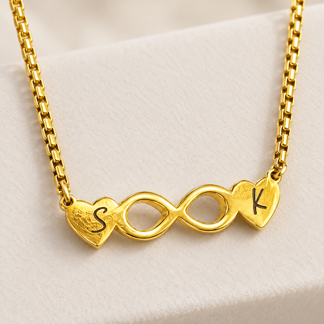 Personalized Infinity Heart Necklace – 18K Gold Plated 2 Close-up of an engraved gold infinity heart necklace with two initials